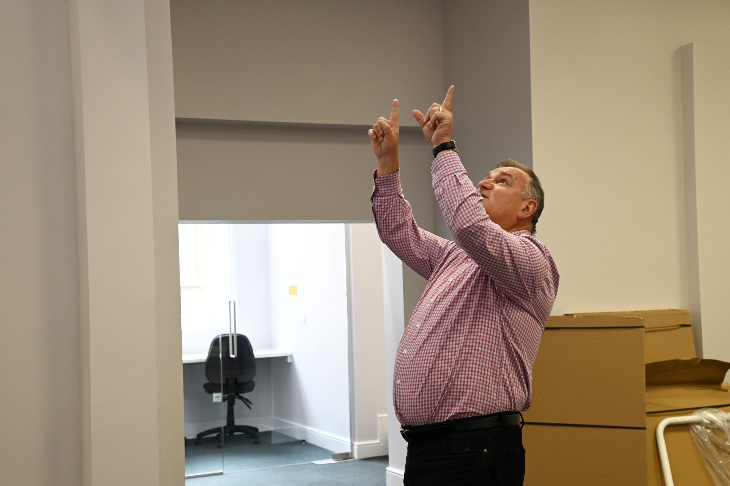 A man looking up measuring office space with his fingers